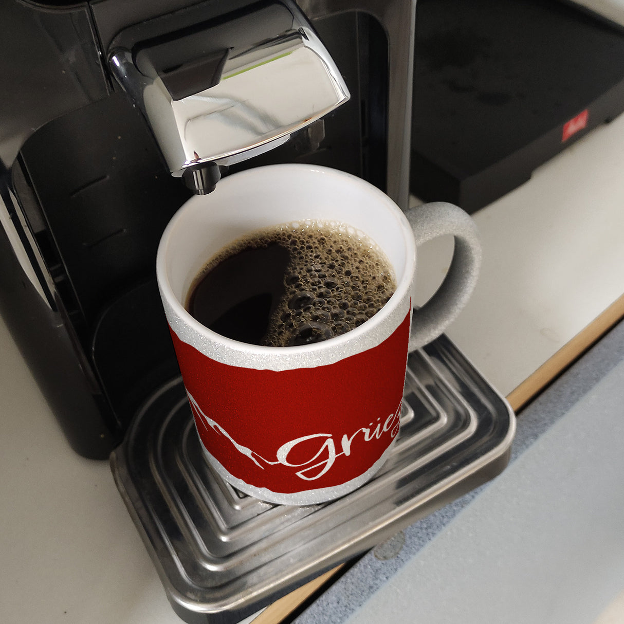 Kaffeebecher mit Grüezi-Schriftzug mit Herz und Bergen