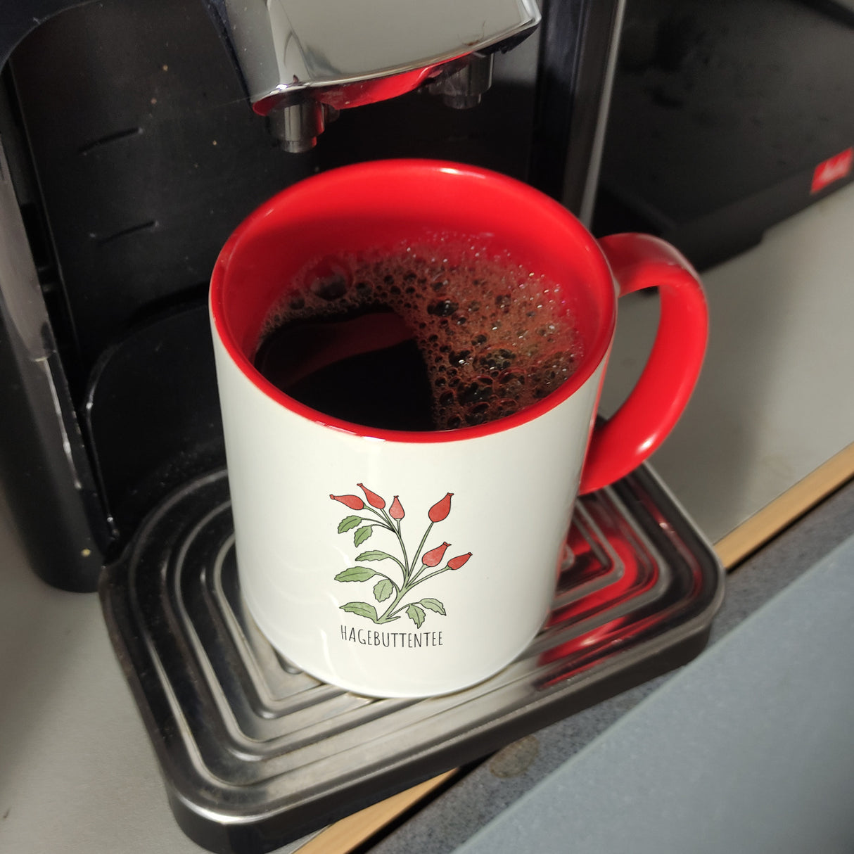 Hagebuttentee Teetasse mit Hagebuttenpflanze für Teetrinker