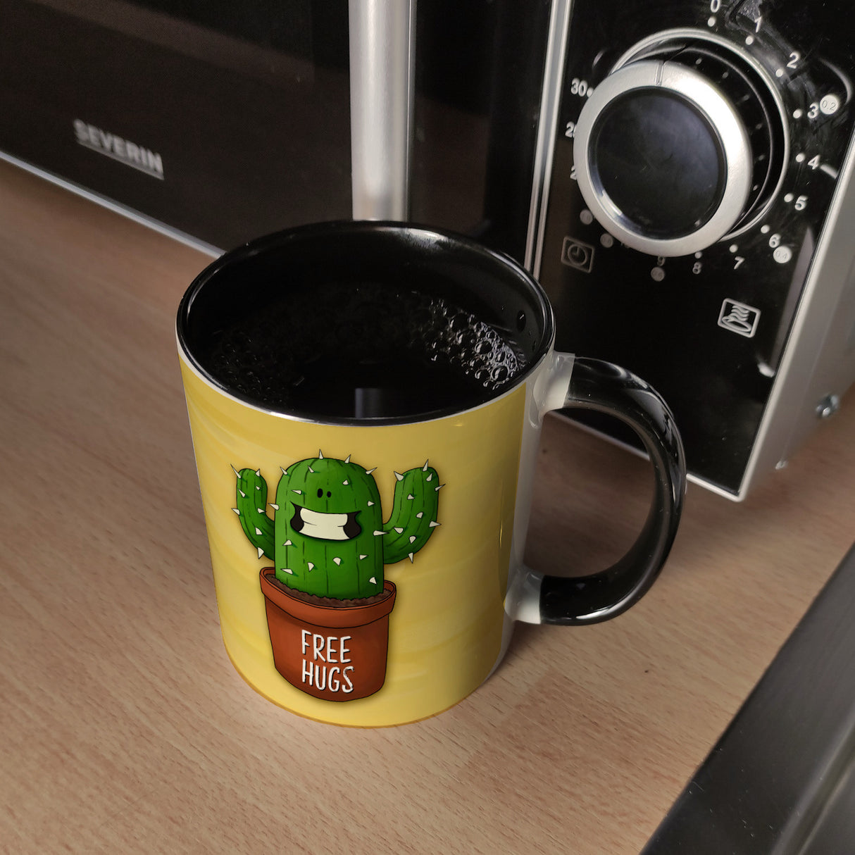 Kaffeebecher mit freundlicher Kaktus Motiv und Spruch: Free Hugs