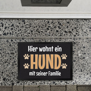 Hier wohnt ein Hund mit seinem Personal Fußmatte