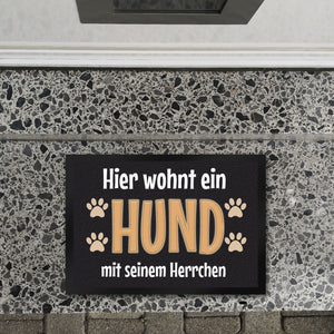 Hier wohnt ein Hund mit seinem Personal Fußmatte