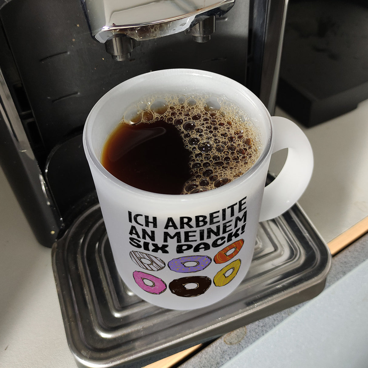 Ich arbeite an meinem Six Pack Kaffeebecher mit bunten Donuts
