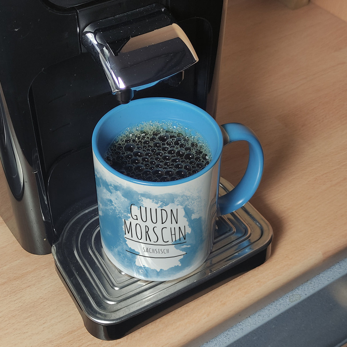 Hallo auf Sächsisch Guudn Morschen lustiger Kaffeebecher mit blauem Hintergrund