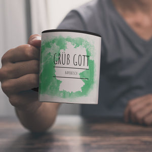 Hallo auf Bayerisch Grüß Gott lustiger Kaffeebecher mit grünem Hintergrund