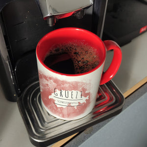 Hallo auf Schweizerdeutsch Grüezi lustiger Kaffeebecher mit rotem Hintergrund