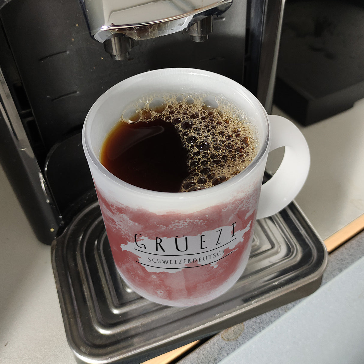 Hallo auf Schweizerdeutsch Grüezi lustiger Kaffeebecher mit rotem Hintergrund