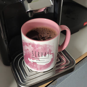 Hallo auf Wienerisch Servas lustiger Kaffeebecher mit rosaem Hintergrund