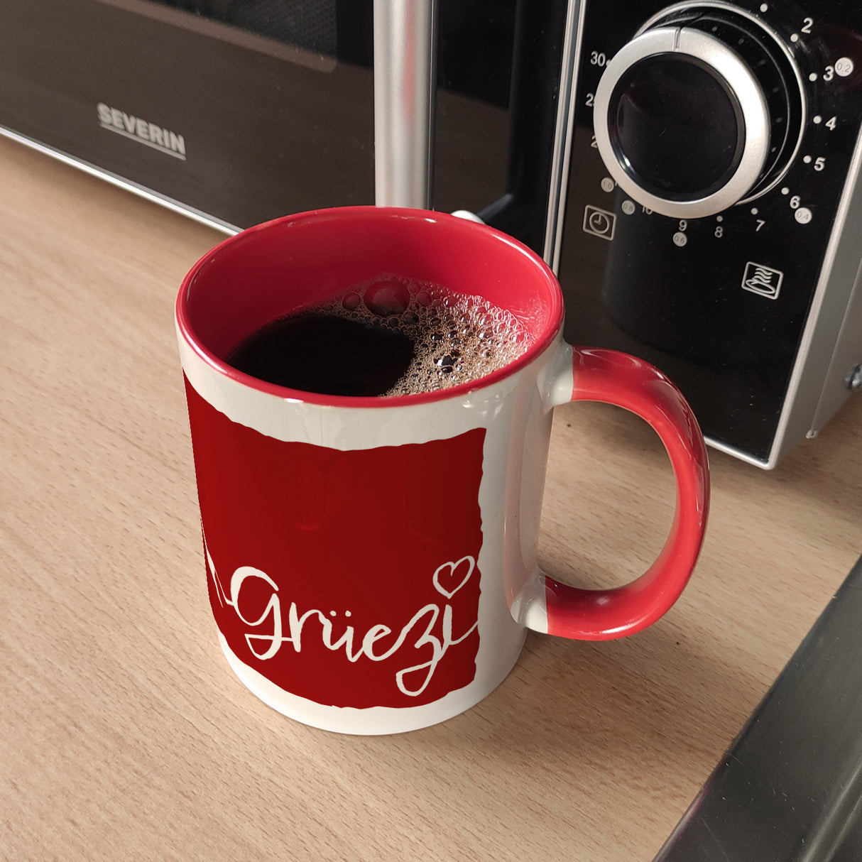 Kaffeebecher mit Grüezi-Schriftzug mit Herz und Bergen