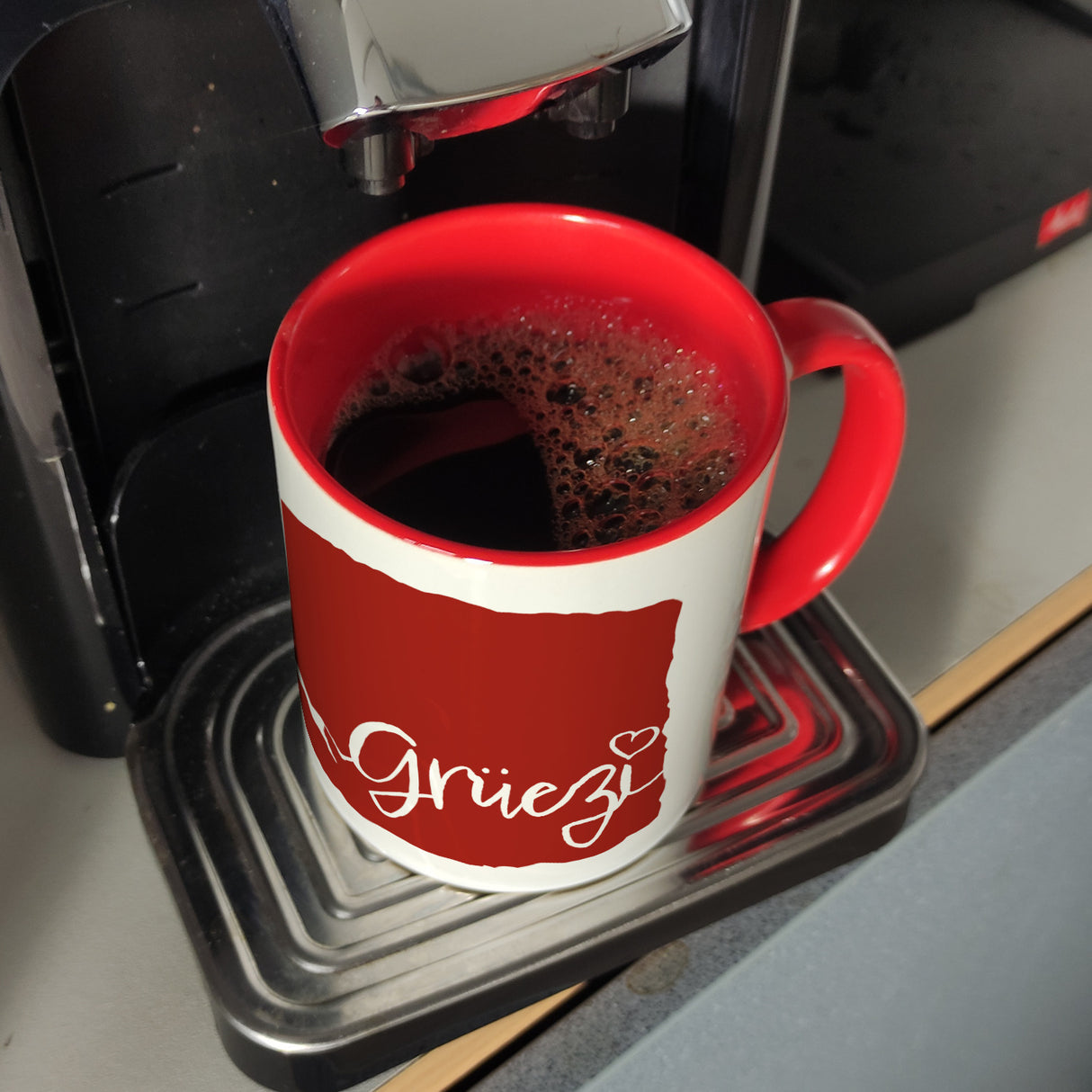 Kaffeebecher mit Grüezi-Schriftzug mit Herz und Bergen