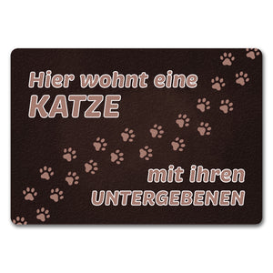 Hier wohnt eine Katze mit ihren Untergebenen Fußmatte mit Pfotenabdrücken