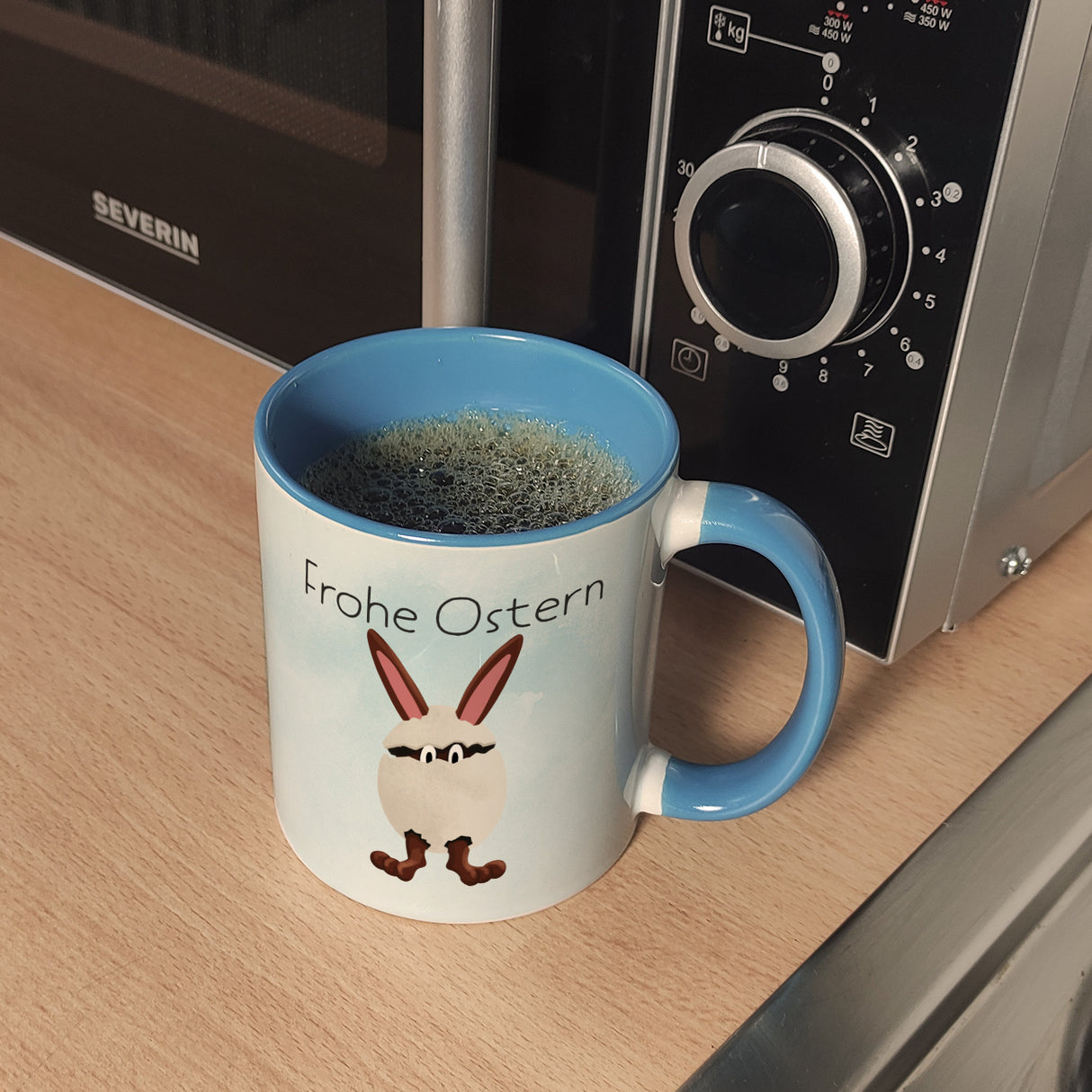 Frohe Ostern Kaffeebecher mit lustigem Osterhasen in Eierschale