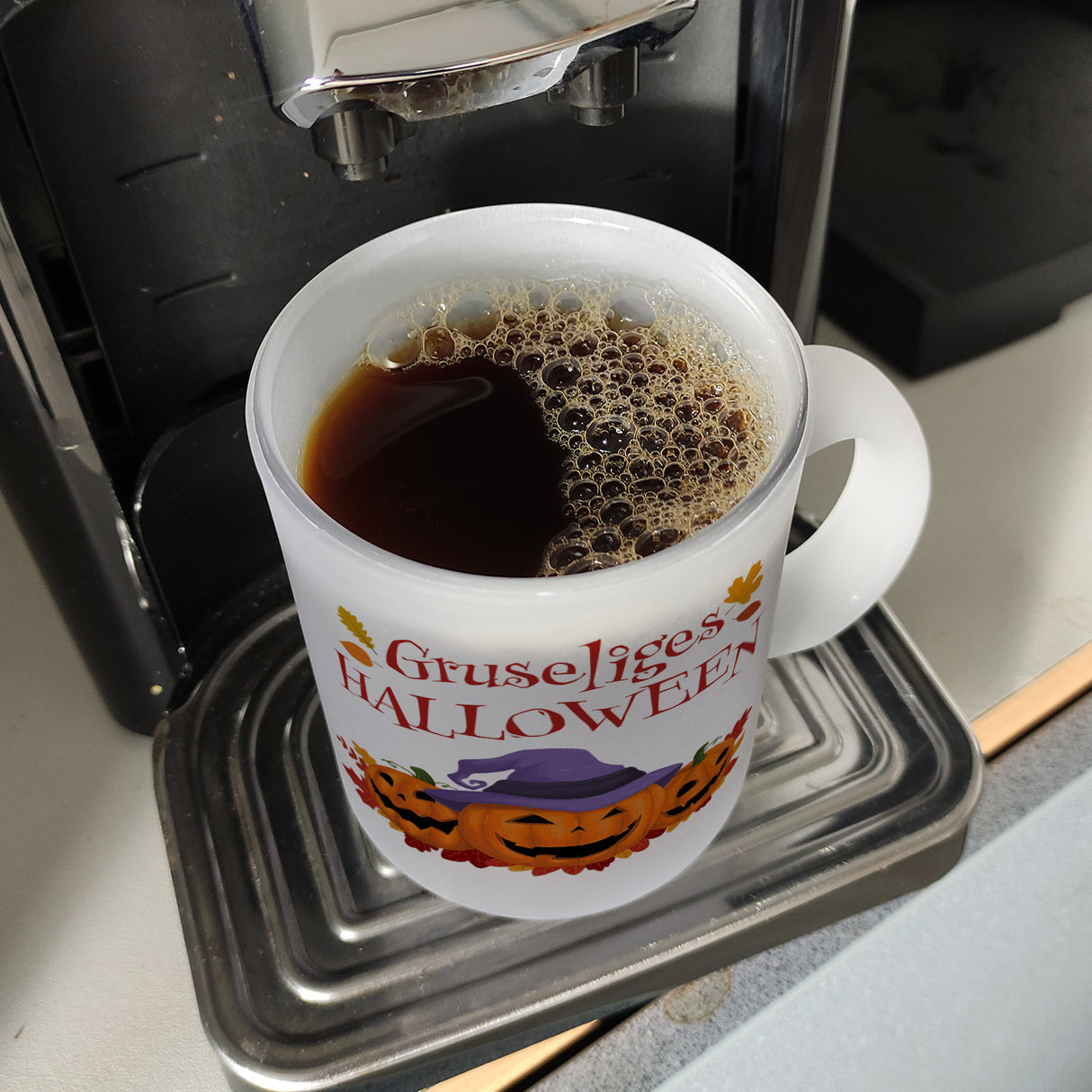 Gruseliges Halloween Kaffeebecher mit grinsenden Kürbissen
