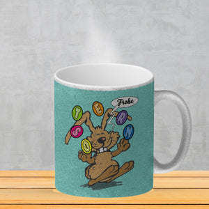 Frohe Ostern! Osterhase jongliert mit Ostereiern Kaffeebecher in {weiß}