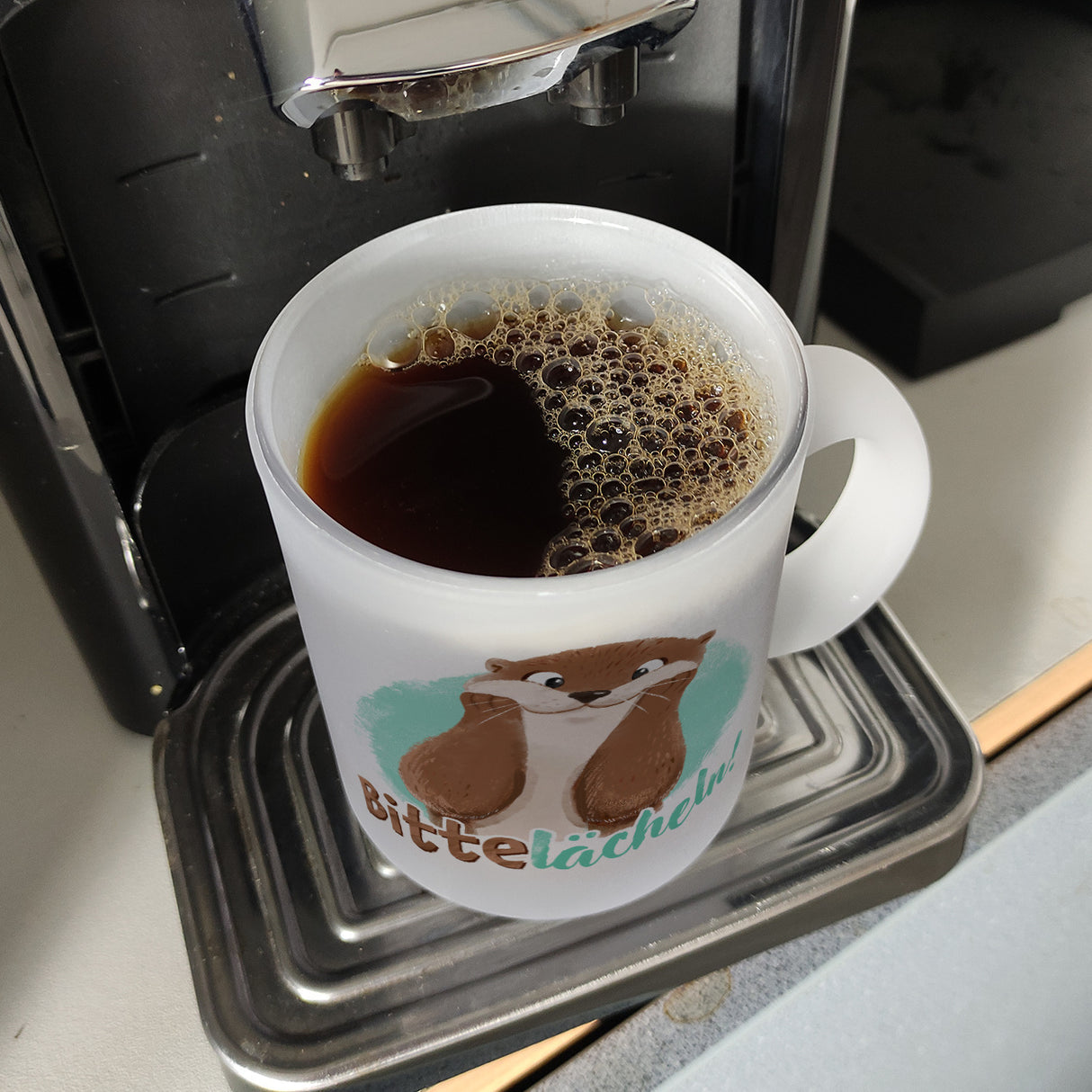 Lachender Otter Kaffeebecher mit Spruch Bitte lächeln