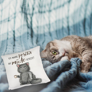 Genervte Katze Kissen mit Spruch positiv auf müde getestet