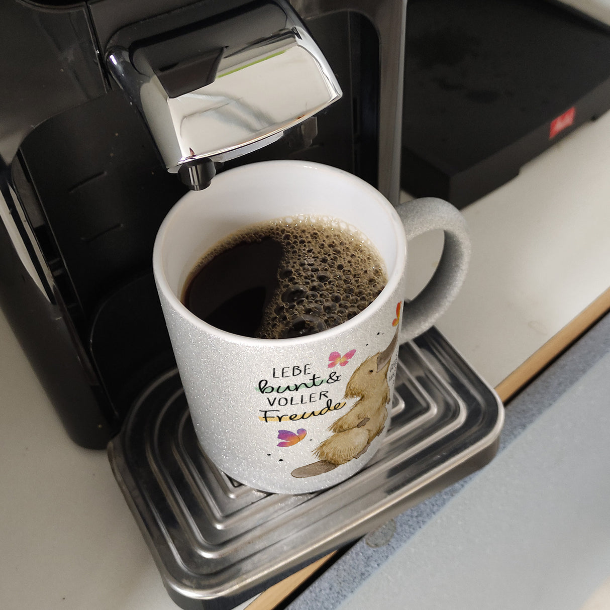 Schnabeltier Kaffeebecher mit Spruch Lebe bunt und freudig