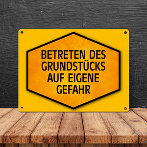 Betreten des Grundstücks auf eigene Gefahr Warn- und Hinweisschild in Gelb und Schwarz