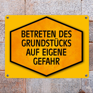 Betreten des Grundstücks auf eigene Gefahr Warn- und Hinweisschild in Gelb und Schwarz