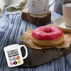 Ich arbeite an meinem Six Pack Kaffeebecher mit bunten Donuts