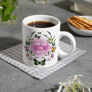 Kaffeebecher mit motivierenden Worten und Blumenrahmen mit Schmetterlingen