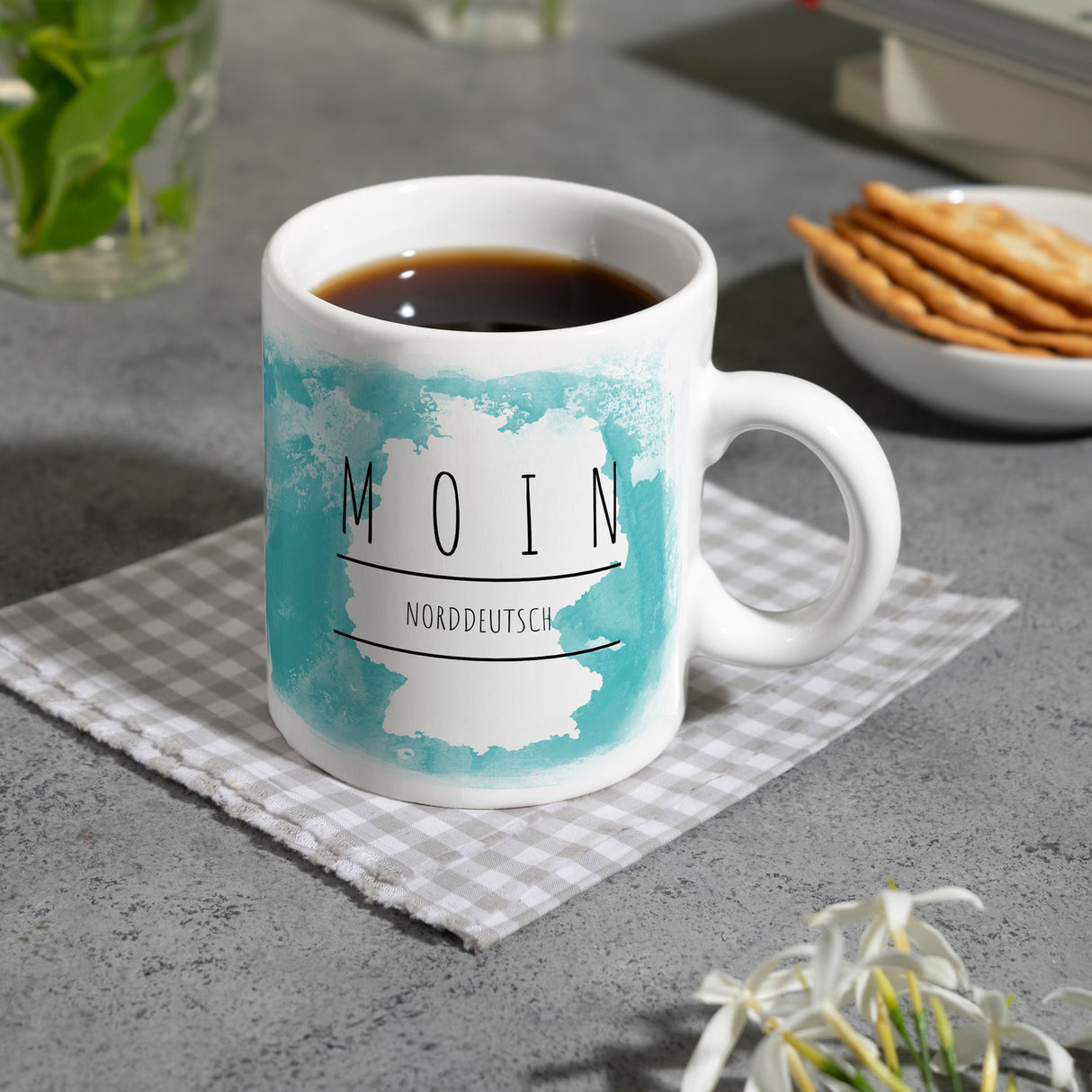Hallo auf Norddeutsch Moin lustiger Kaffeebecher mit blauem Hintergrund