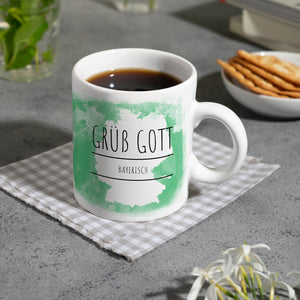 Hallo auf Bayerisch Grüß Gott lustiger Kaffeebecher mit grünem Hintergrund