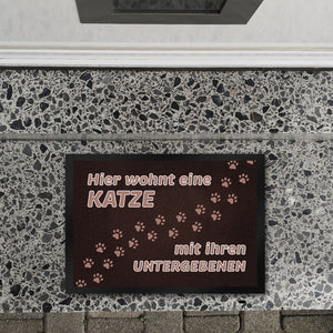 Hier wohnt eine Katze mit ihren Untergebenen Fußmatte mit Pfotenabdrücken
