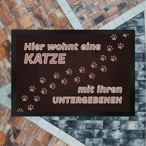 Hier wohnt eine Katze mit ihren Untergebenen Fußmatte mit Pfotenabdrücken